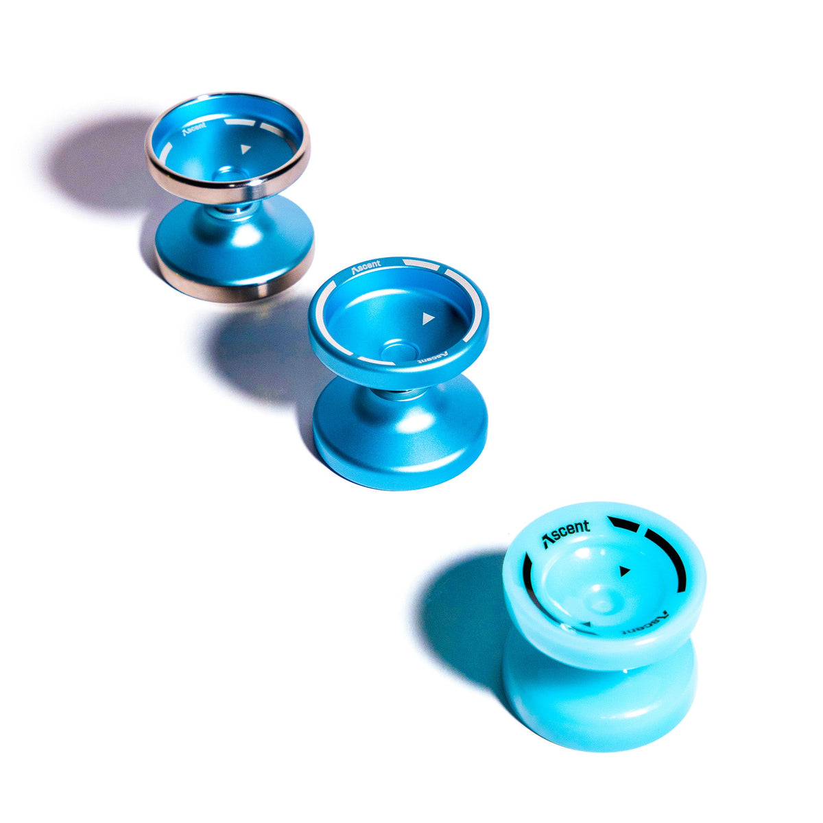 Three Aqua Ascent yoyos from the Learn to Yo-Yo in 90 Days kit arranged from above