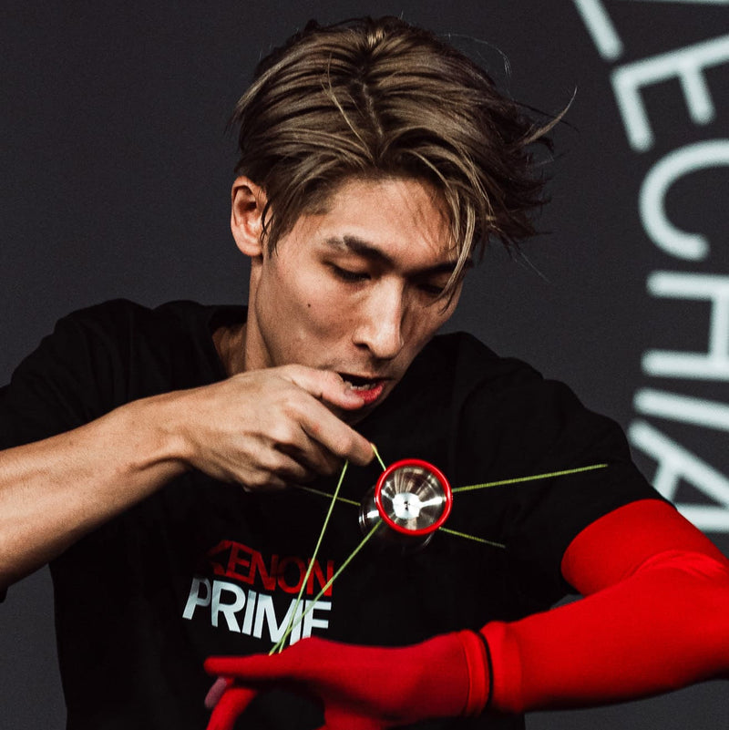 Professional yo-yo Xavier Ng player performing an advanced string trick with a red yo-yo at the World Yo-Yo Contest